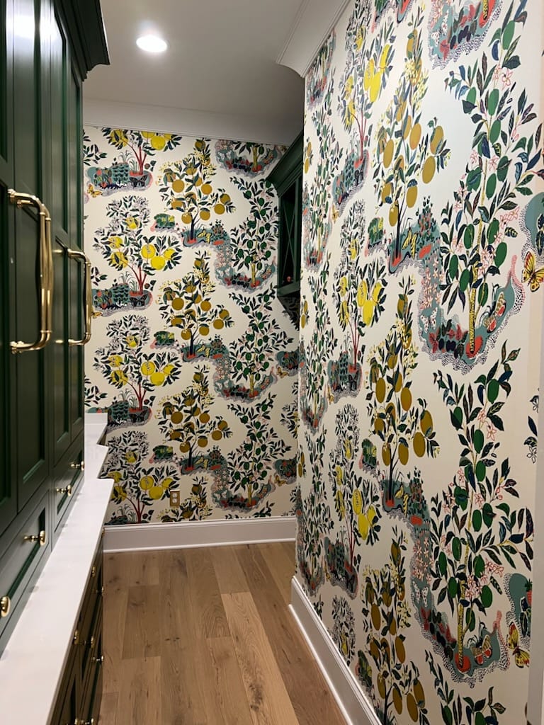 Colorful citrus botanical wallpaper in pantry with green cabinetry by Lillian's Interiors