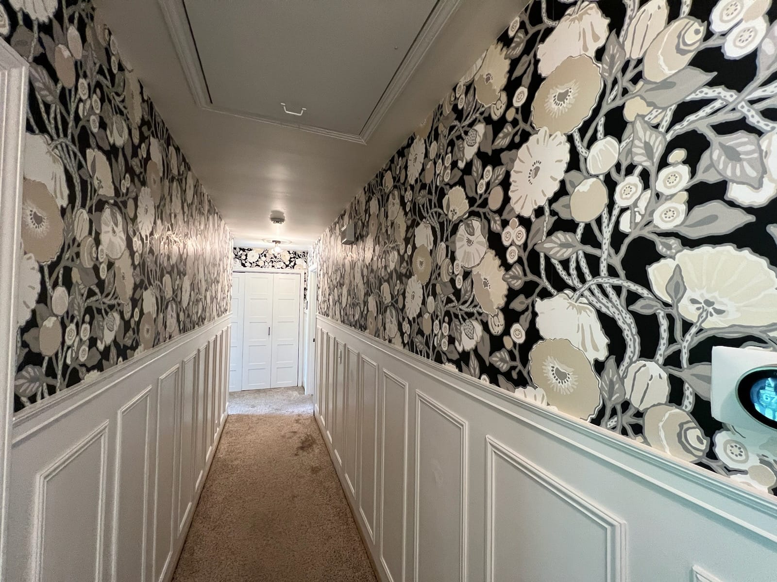 Black and cream floral wallpaper hallway with wainscoting by Lillian's Interiors